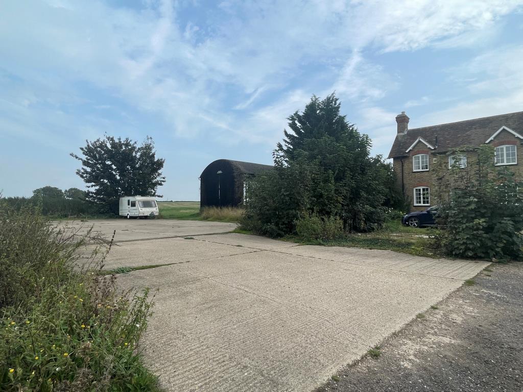 Lot: 145 - DETACHED COTTAGE ON TWO ACRE PLOT WITH DILAPIDATED BARN AND HARDSTANDING - View of site with hardstanding and barn
